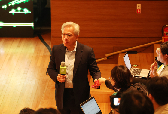 Nvidia CEO Jensen Huang hands out Pepero to reporters at a press briefing held at Gyeongju, North Gyeongsang, on Oct. 31, after delivering his keynote speech for the Asia Pacific Economic Cooperation (APEC) CEO Summit. 