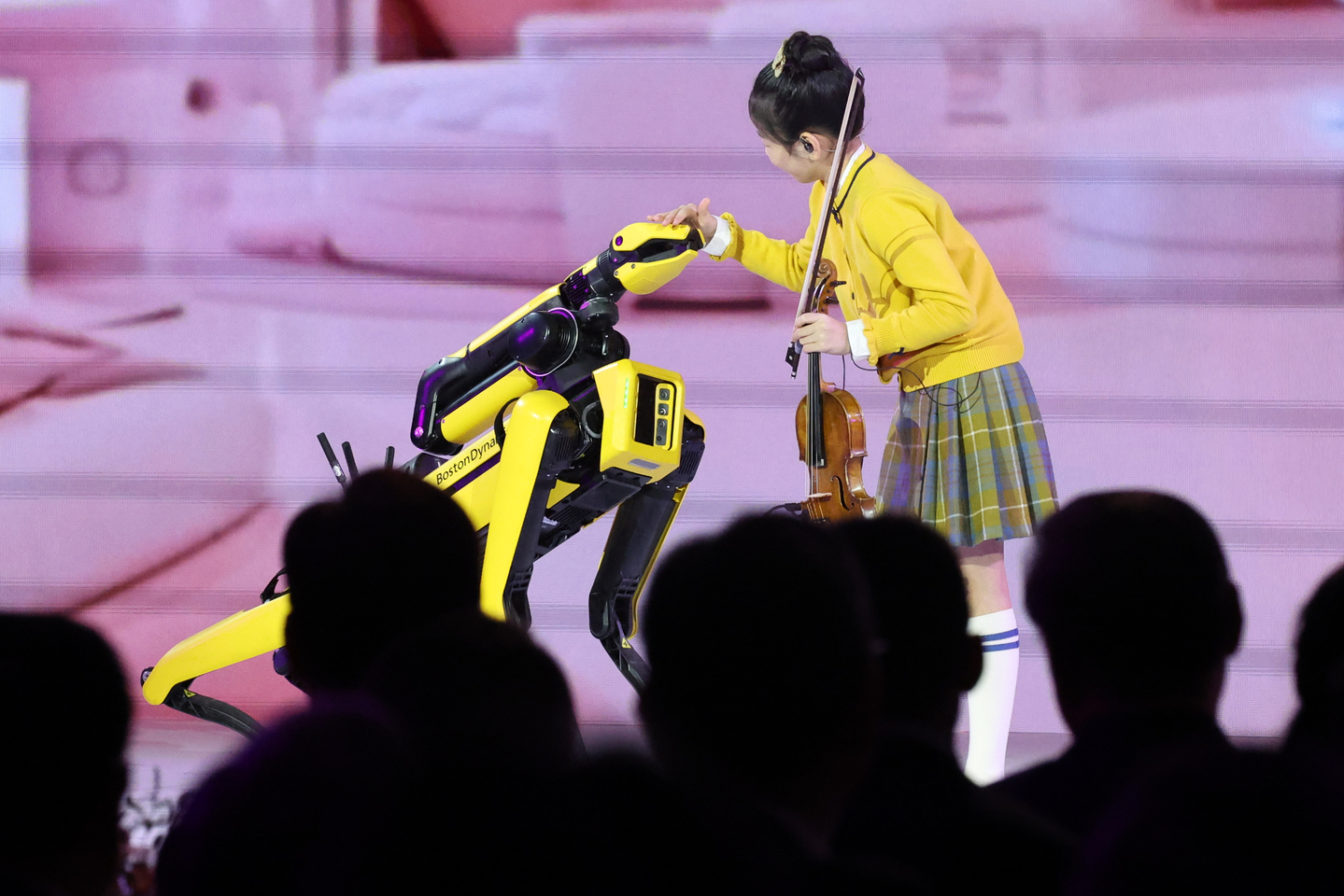 Violinist Kim Yeon-ah pats a robot dog from Hyundai Motor-backed Boston Dynamics at the APEC summit gala dinner in Gyeongju, North Gyeongsang, on Oct. 31. [YONHAP]