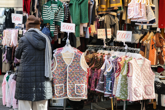 A shopper looks at padded vests at the Namdaemun Market in central Seoul on Oct. 27 as the weather gets colder across the country. [YONHAP]