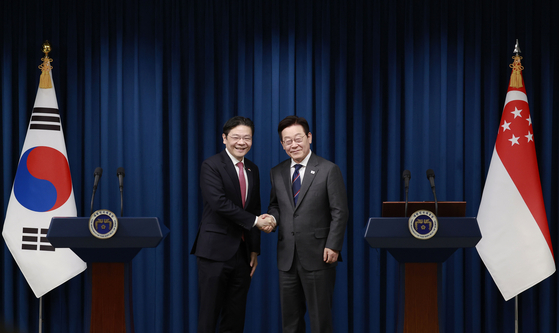 President Lee Jae Myung, right, shakes hands with Singaporean Prime Minister Lawrence Wong during a joint press conference at the presidential office in Seoul on Nov. 2, 2025. [PRESIDENTIAL OFFICE]