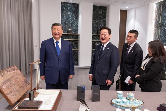President Lee Jae Myung, second from left, and Chinese President Xi Jinping, left, smile as they exchange gifts after their summit meeting on the sidelines of the APEC gathering in Gyeongju, North Gyeongsang on Nov. 1. [YONHAP]