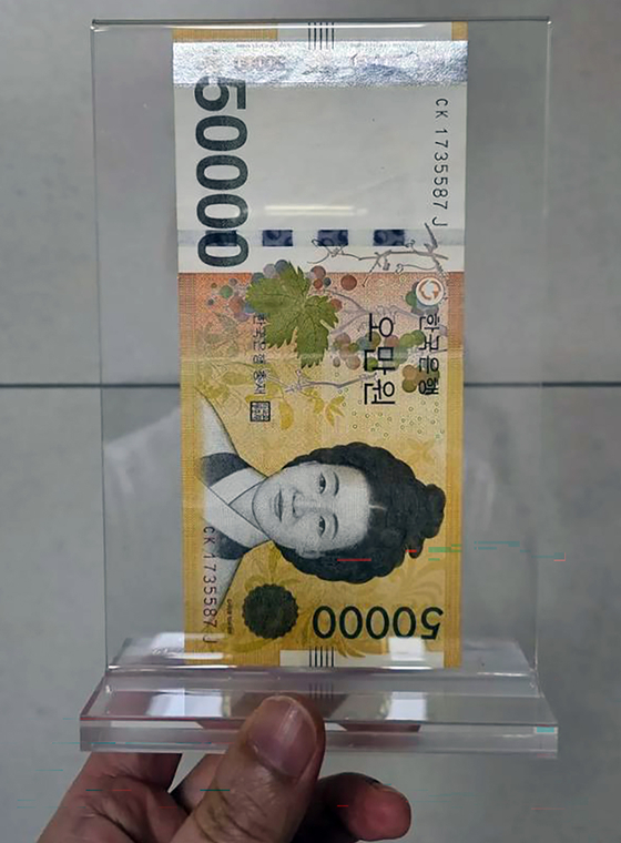 A 50,000 won ($35) bill that Samsung Electronics Executive Chairman Lee Jae-yong gave to a cafe employee in return for a free cup of coffee is displayed in a frame. [SCREEN CAPTURE]