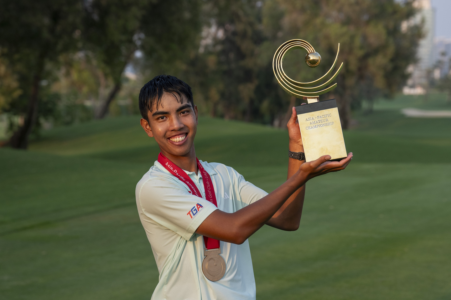 Fifa Laopakdee lifts the 2025 Asia-Pacific Amateur Championship trophy following a playoff at the Emirates Golf Club Majlis Course in Dubai, United Arab Emirates on Oct. 26. [AAC]