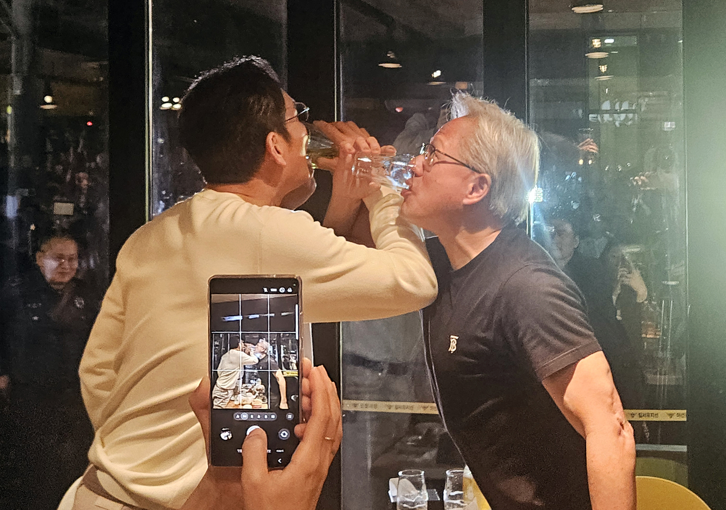 Nvidia CEO Jensen Huang, right, drinks a glass of beer with his arms entwined with Samsung Electronics Chairman Lee Jae-yong, left and Hyundai Motor Group Executive Chair Euisun Chung during their causal dinner of chimaek, the Korean term for chicken and beer, in Samseong-dong, southern Seoul, on Oct. 30. [YONHAP]