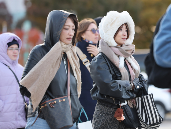 Citizens and tourists walk are seen in heavy clothing in the streets of Gwanghwamun, central Seoul, as temperatures drop on Nov. 2. [YONHAP]