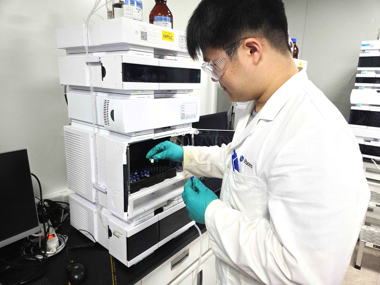 Ying Wei Wang inspects samples at a lab. [HUONS]