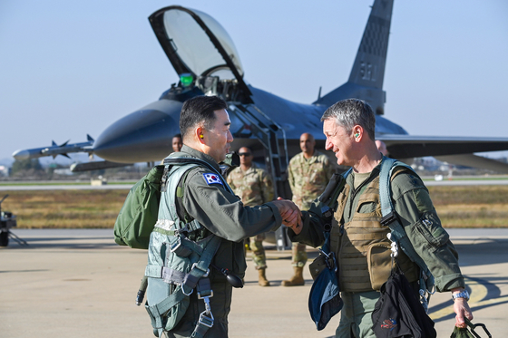 South Korean Joint Chiefs of Staff (JCS) Chairman Gen. Jin Yong-sung, left, and his U.S. counterpart, Gen. Dan Caine, shake hands before the allies’ first-ever combined formation flight in the skies above Korea on Nov. 3. [JOINT CHIEFS OF STAFF]