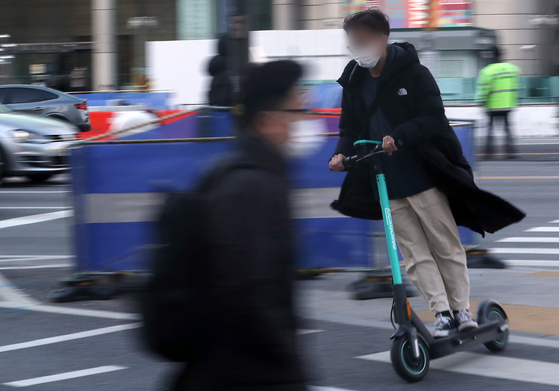 A commuter rides an e-scooter on the streets of Gwanghwamun, central Seoul, on Dec. 9, 2020. The picture is unrelated to the story. [NEWS1]