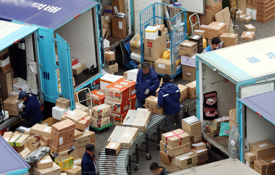 Delivery workers prepare parcels for shipment at a logistics center in Seoul on Nov. 13, 2020. [NEWS1]