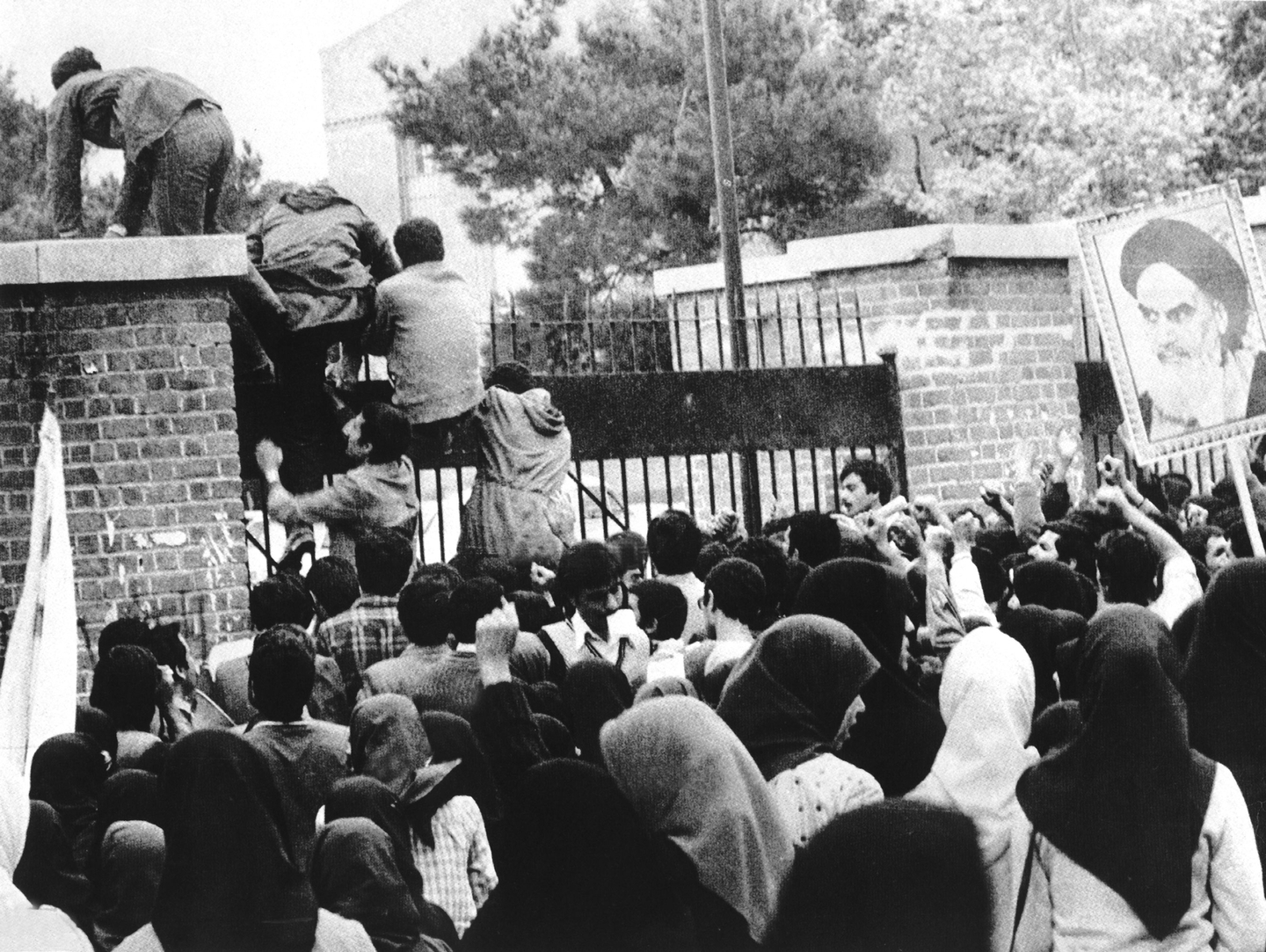 Iranian students climb up U.S. embassy gates in Tehran. [WIKIPEDIA]