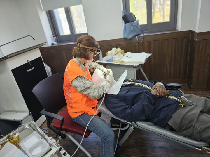 A dental hygienist is performing a scaling procedure on a patient during Myongji University's free health check-up program. [MYONGJI UNIVERSITY]