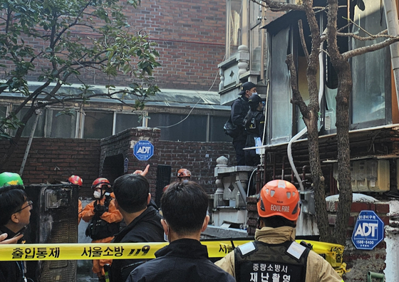 Police officers and firefighters inspect the scene after a fire breaks out at a residential building in Jungnang District, eastern Seoul, on Nov. 5. [YONHAP]