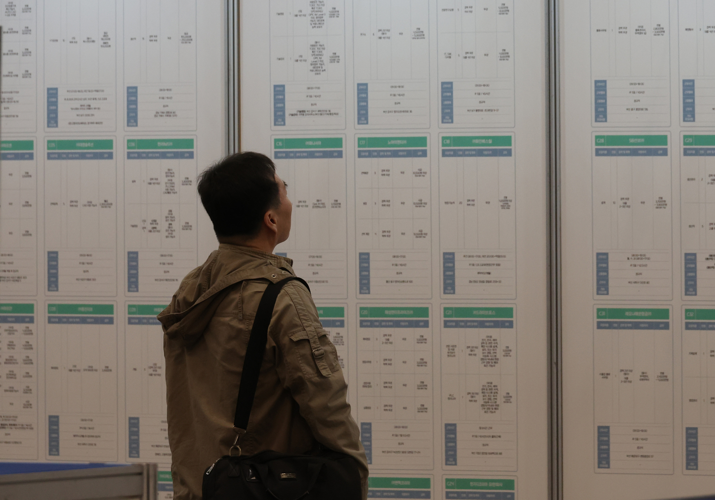A job seeker looks at a recruitment board during the 2025 Busan Job Festival, an event offering employment opportunities for all age groups, at Bexco in Haeundae District, Busan, on Oct. 27. [SONG BONG-GEUN]