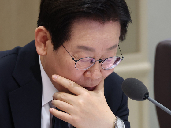 President Lee Jae Myung reviews documents while receiving briefings from ministries during a Cabinet meeting at the presidential office in Yongsan District, Seoul, on Nov. 4. [YONHAP]