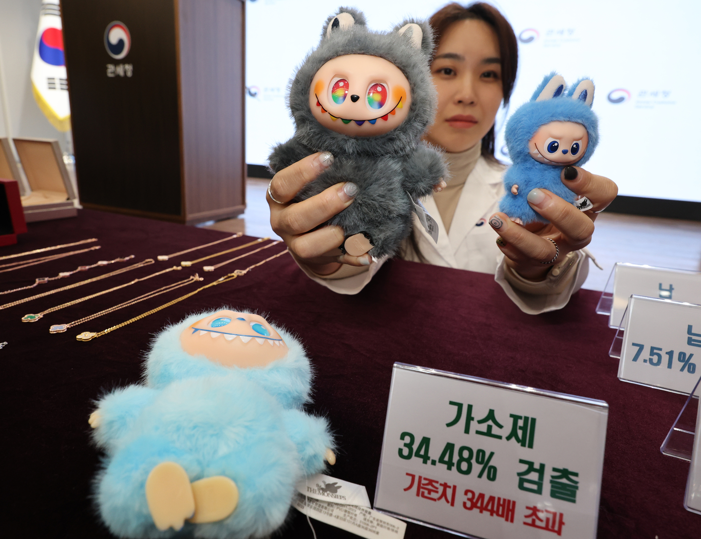 A Korea Customs Service official displays a counterfeit Labubu keyring that tested positive for toxic chemicals, alongside a genuine version of the toy, during a press briefing held in Gangnam District, southern Seoul, on Nov. 5. [YONHAP]