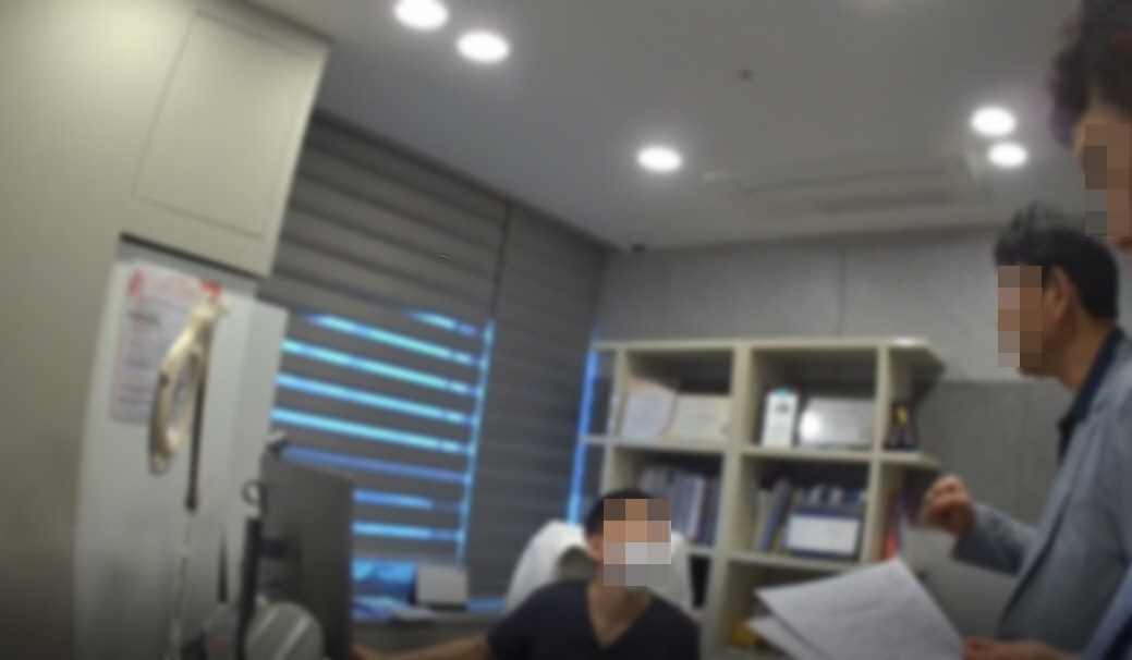 An investigator from the Busan Metropolitan Police Agency’s narcotics crime unit notifies a doctor at a hospital in Busan of a search and seizure warrant for allegedly overprescribing psychotropic appetite suppressants. [BUSAN METROPOLITAN POLICE AGENCY]