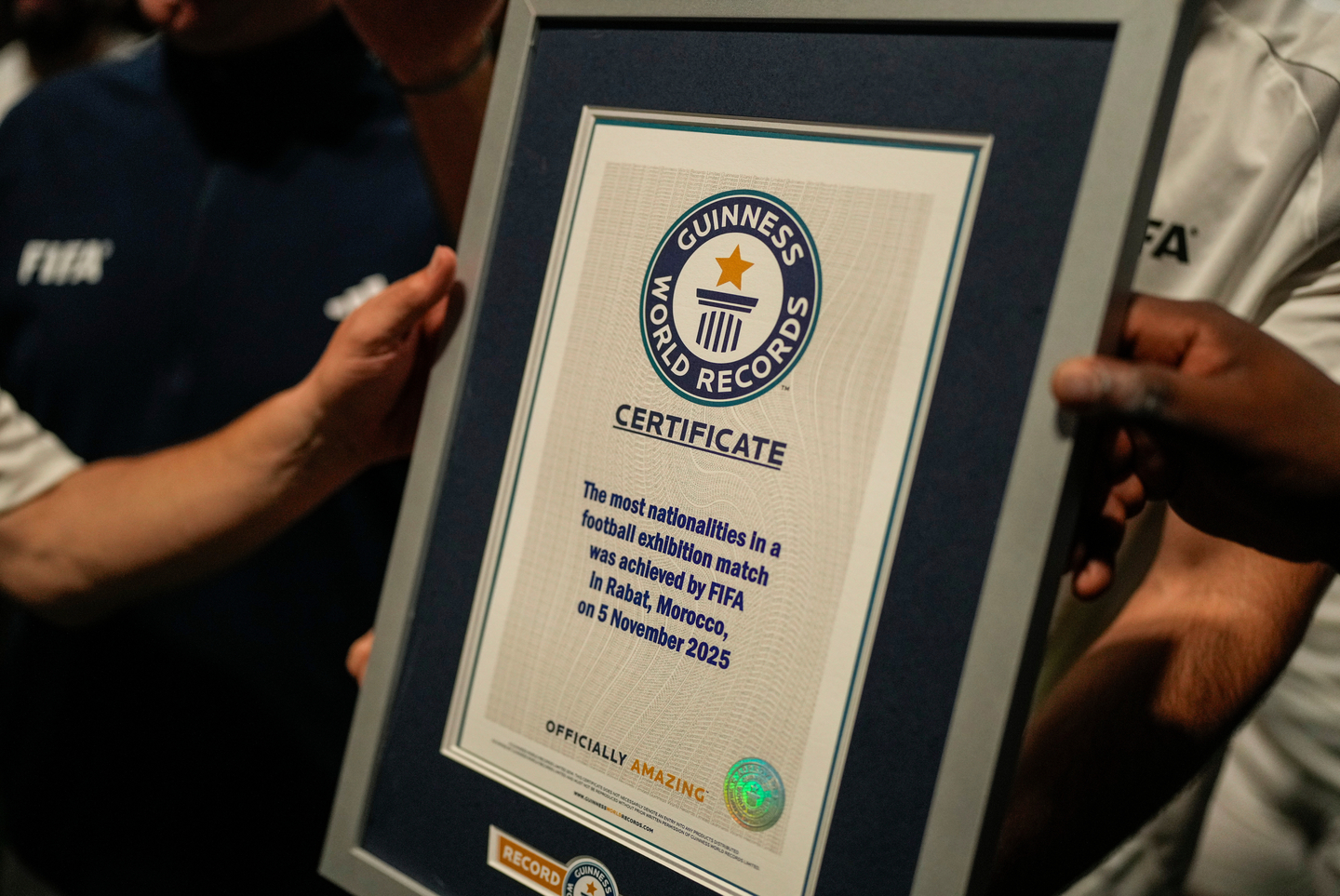 People hold a certificate after breaking the Guinness World Record for most nationalities in an exhibition soccer match organized by FIFA, in Rabat, Morocco, Wednesday, Nov. 5. [AP/YONHAP]