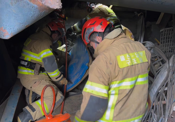Firefighters rescue a buried worker following the collapse of a boiler tower at the Ulsan Thermal Power Plant in Nam District, Ulsan, on Nov. 7. [ULSAN FIRE DEPARTMENT