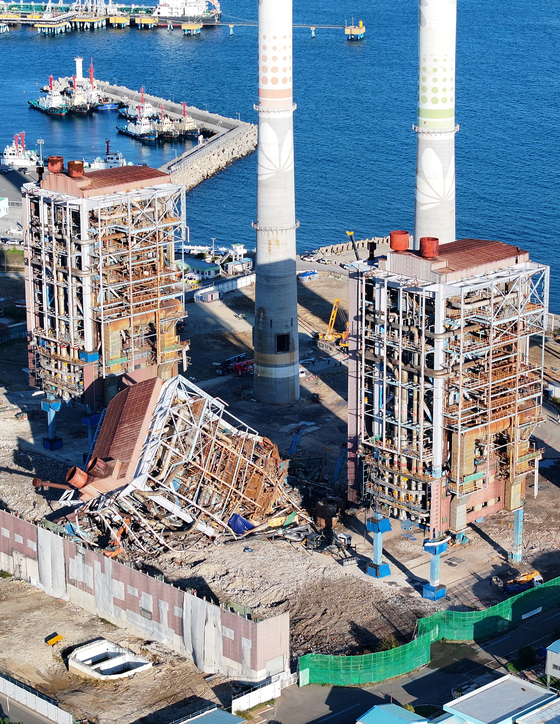 A boiler tower at the Ulsan Thermal Power Plant is seen collapsed in Nam District, Ulsan, on Nov. 10. Fire authorities have suspended the search while conducting preliminary work to bring down reactors No. 4 and 6, located on either side of the collapsed boiler tower No. 5. [YONHAP]