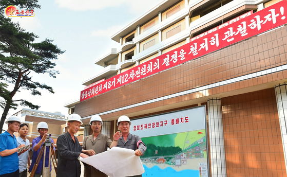 Construction workers and officials are seen near Yeombunjin in North Korea in this file photo released by the Korean Central News Agency. [KOREAN CENTRAL NEWS AGENCY] 