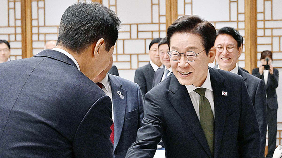 President Lee Jae Myung, right, shakes hands with Seoul Mayor Oh Se-hoon during the ninth Central and Local Government Cooperation Council meeting at the presidential office in Yongsan, central Seoul, on Nov. 12. [JOINT PRESS CORPS]