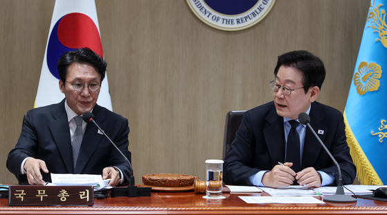 President Lee Jae Myung, right, asks a question to Prime Minister Kim Min-seok during a Cabinet meeting held at the Presidential Office in Yongsan, central Seoul, on Nov. 11. [JOINT PRESS CORPS]