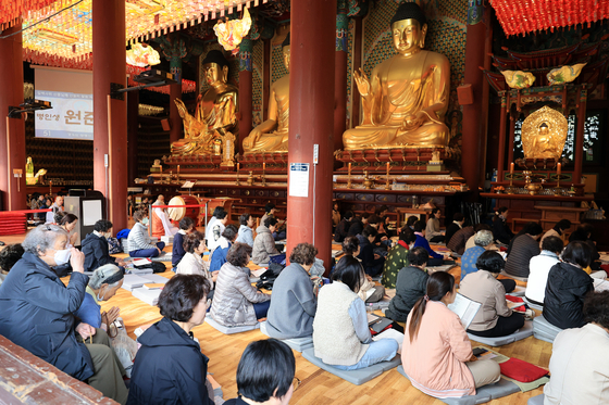 Families and relatives of College Scholastic Ability Test (CSAT)-takers pray at Jogye Temple in central Seoul on Nov. 9. [NEWS1]