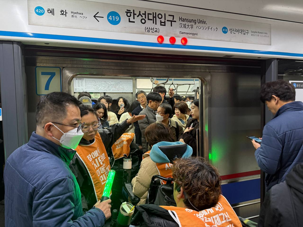Activists under the Solidarity Against Disability Discrimination (SADD) protest at Hansung University Station, Seoul Metro Line No. 4, during the morning rush hour on Nov. 12. [YONHAP]