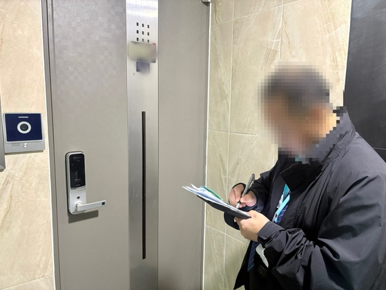Park, a census taker for the 2025 Population and Housing Census, writes a notice at a multifamily housing unit in Seoul on Nov. 7. [LEE AH-MI]