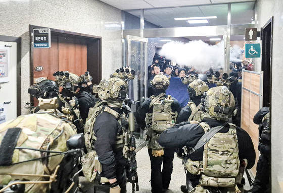 Parliamentary staff use fire extinguishers to repel martial law forces inside the National Assembly in Yeouido, western Seoul, on Dec. 4, 2024. [YONHAP] 