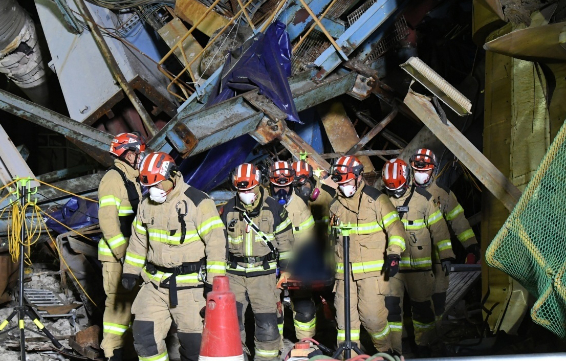 Rescue workers carry a body out of a collapsed building on a stretcher at the site of the Ulsan Thermal Power Plant collapse in Ulsan on the morning of Nov. 12. [NATIONAL FIRE AGENCY]