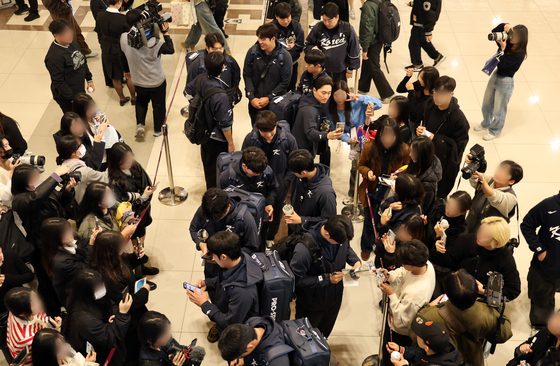 Members of the Korean national baseball team sign autographs for fans at Gimpo International Airport in Seoul on Nov. 12, before traveling to Tokyo for exhibition games against Japan. [YONHAP]