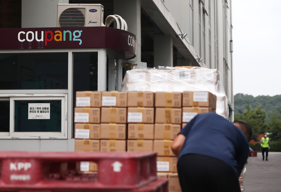 Workers load cargo at a Coupang logistics center in Songpa District, southern Seoul. [YONHAP] 
