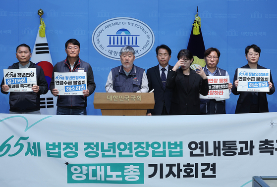 Kim Dong-myung, center, the head of the Federation of Korean Trade Unions, speaks during a joint press conference held by the country’s two major labor unions at the National Assembly in western Seoul on Nov. 5. [LIM HYUN-DONG]