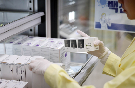 A health worker examines Covid-19 and flu vaccines at a hospital in Gwangju on Oct. 29. [YONHAP] 