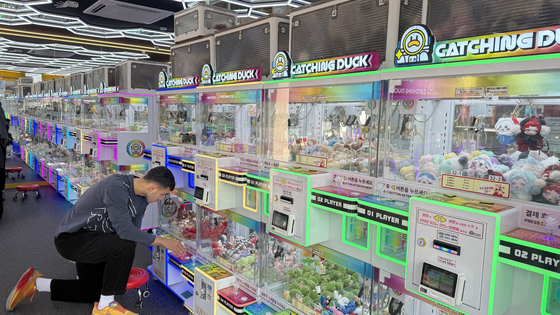 A person plays a claw machine at Catching Duck in Hongdae on Nov. 9. [WOO JI-WON]