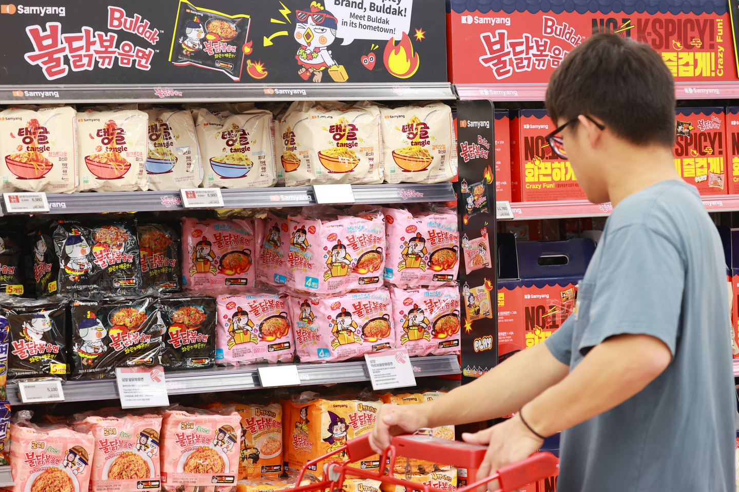A shopper chooses a bag of Samyang Foods' Buldak noodles at a supermarket in Seoul on June 29. [YONHAP]
