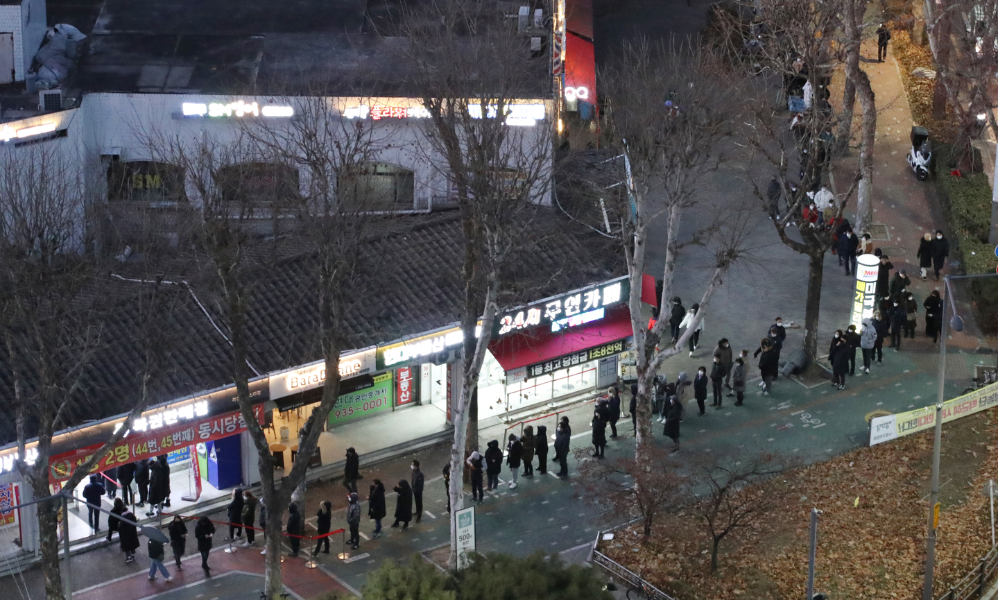 People line up in front of a store known to be a so-called lottery hot spot in Nowon District, northern Seoul, on Jan.1, 2022. [YONHAP] 