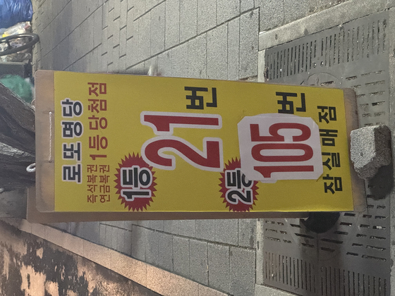 A sign in front of Jamsil Maejeom, a lottery ticket store in Songpa District, southern Seoul, says that the store sold 21 first-prize tickets and 105 second-prize tickets, on Nov.6 [KIM JI-YE]