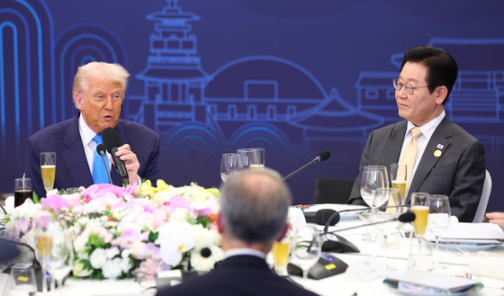 President Lee Jae Myung, right, listens to U.S. President Donald Trump during a dinner at a hotel in Gyeongju, North Gyeongsang, on Oct. 29, following their bilateral summit. [JOINT PRESS CORPS] 
