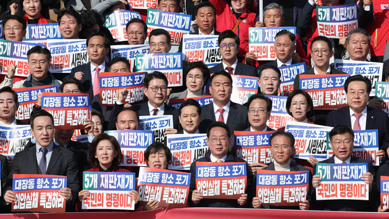Members of the conservative People Power Party hold up placards denouncing the prosecution's decision to not file an appeal in the Daejang-dong case during a rally in front of the National Assembly in Yeouido, western Seoul, on Nov. 12. [LIM HYUN-DONG]