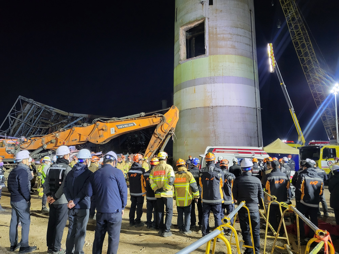 Officials stand in line as the body of the last worker, who was trapped in the collapsed boiler tower of the Ulsan Thermal Power Plant, is recovered on Nov. 14. [NEWS1]