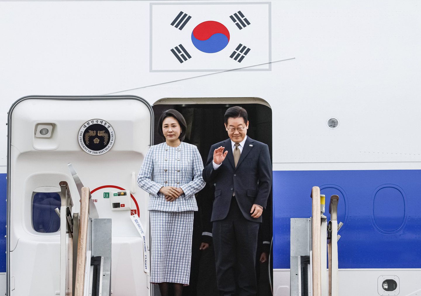 President Lee Jae Myung, right, and first lady Kim Hye Kyung board Air Force One at Seoul Air Base in Seongnam, Gyeonggi, with Lee waving to well-wishers before departing for the Group of 20 summit in South Africa on Nov. 17. [JUN MIN-KYU]