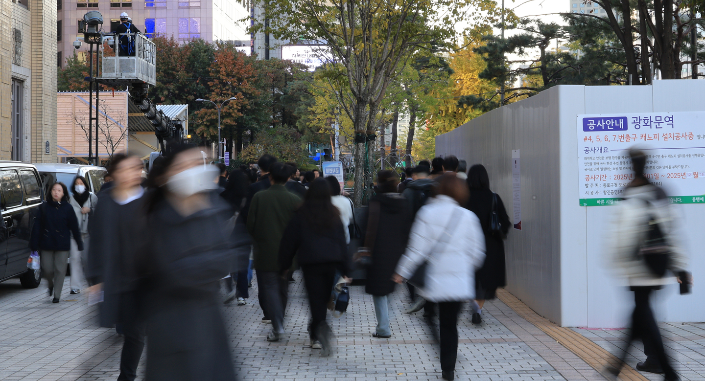 Pedestrians walk near Gwanghwamun Station in central Seoul on Nov. 11. [YONHAP]