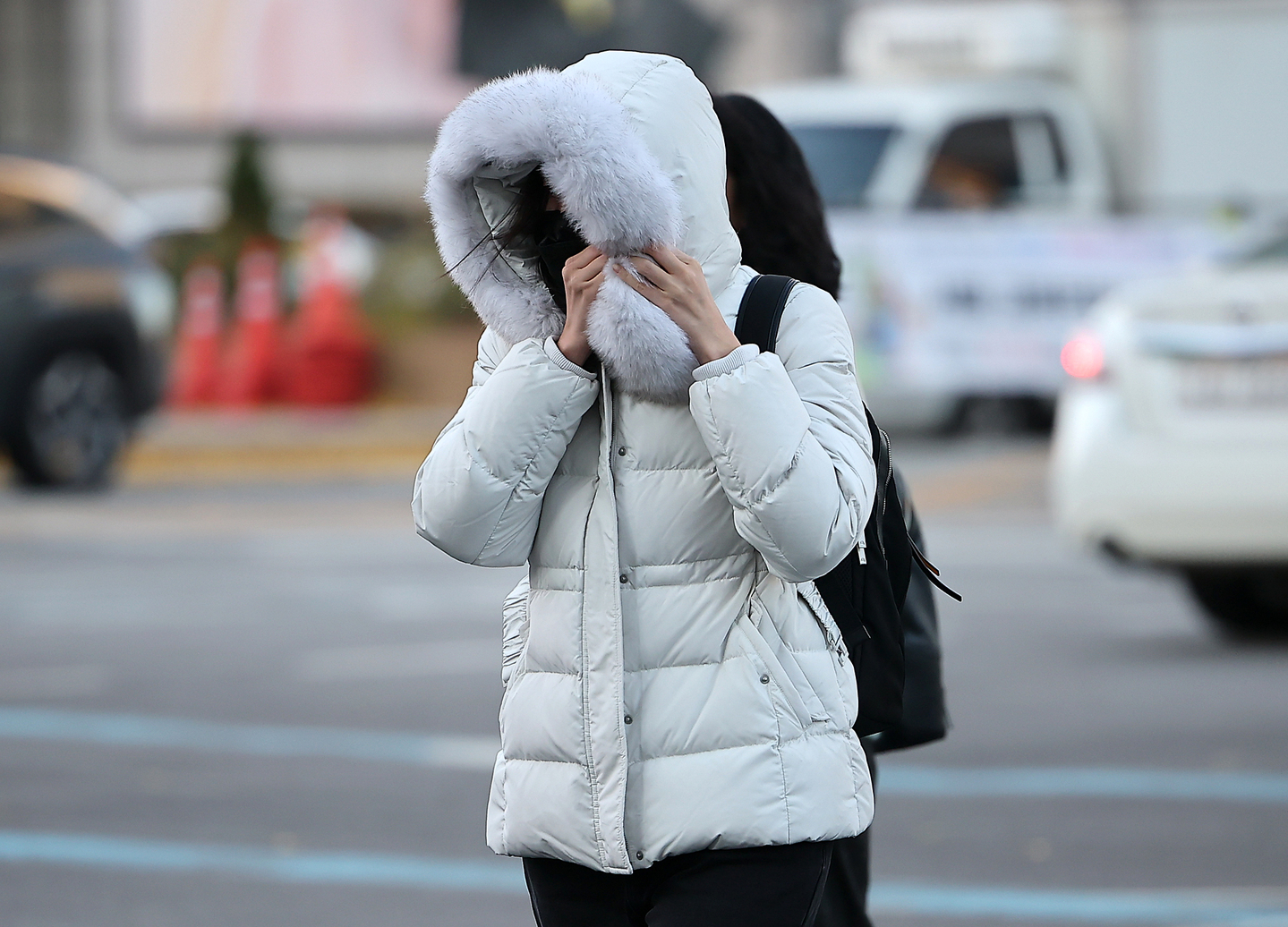 A citizen walks across the Gwanghwamun street in central Seoul with a thick padded coat as temperatures drastically dropped on Nov. 18. [NEWS1]