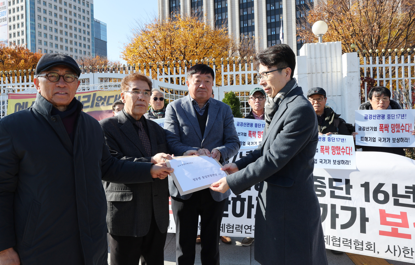 Members of an association of businessmen and investors involved in inter-Korean economic cooperation projects deliver a letter containing their calls to an official of the Unification Ministry on Nov. 18 at the government complex in central Seoul. [YONHAP]