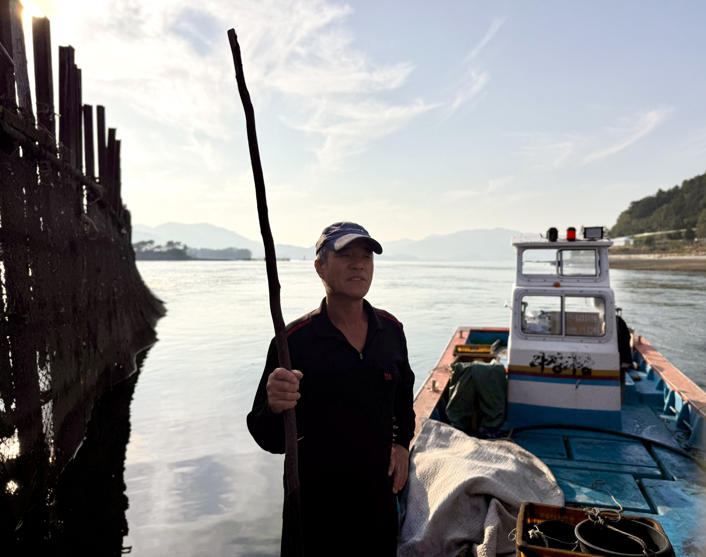 Kim Min-sik, a 66-year-old anchovy fisher, stands on his fishing boat near his jukbangryeom (bamboo fishing weir) in Jijok Strait in Namhae County, South Gyeongsang, on Nov. 5. [LEE SOO-JUNG]