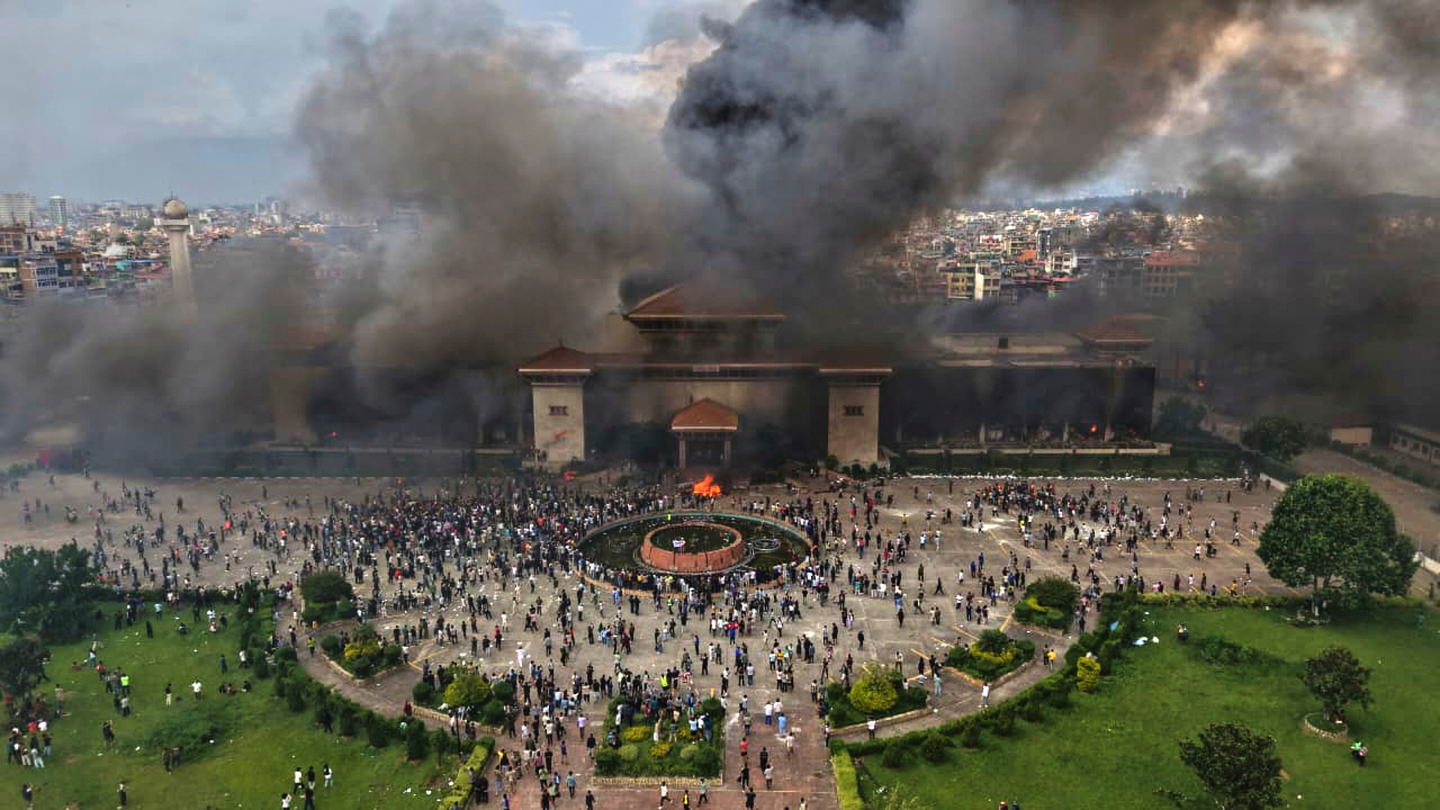 Protesters celebrate at the parliament building after it was set on fire during a protest against a social media ban and corruption in Kathmandu, Nepal, on Sept. 9. [AP/YONHAP]