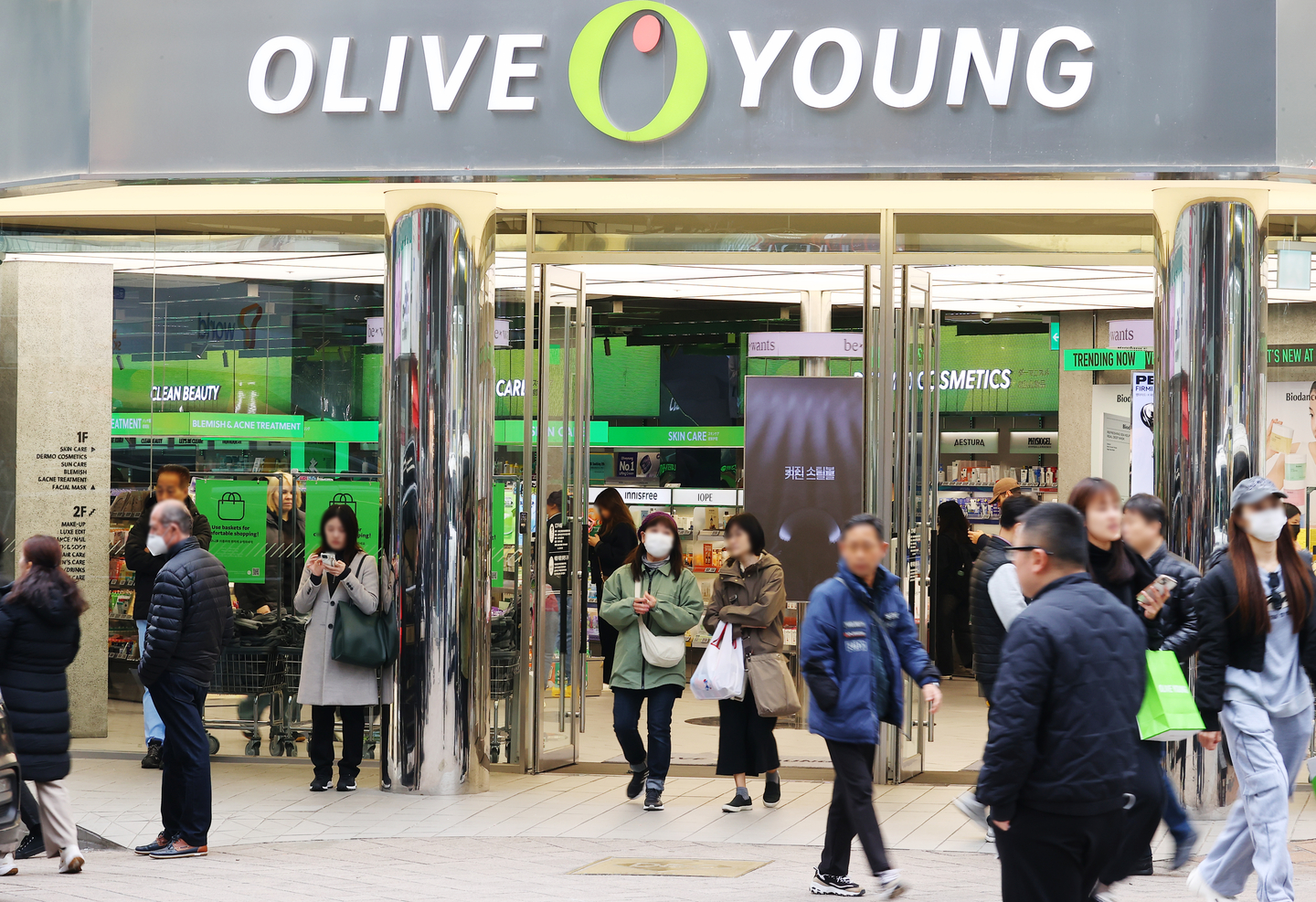 Customers enter and leave an Olive Young store in Seoul on March 12. [YONHAP]