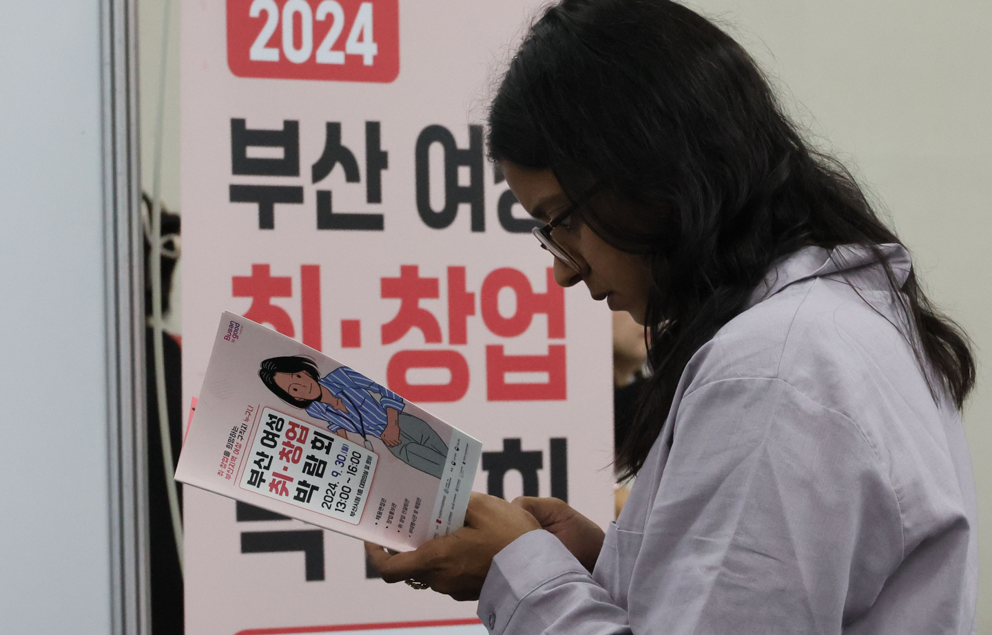 A visitor is seen reading through leaflets at a job fair for women hosted by the Busan city government and the Busan Women's Culture Center, where special programs for women who have had to leave the workforce due to marriage or parenting were provided, at Busan City Hall on Sept. 30, 2024. [SONG BONG-GEUN]